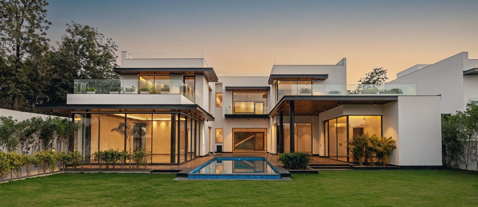 Contemporary BMB villa with lawn and pool at dusk
